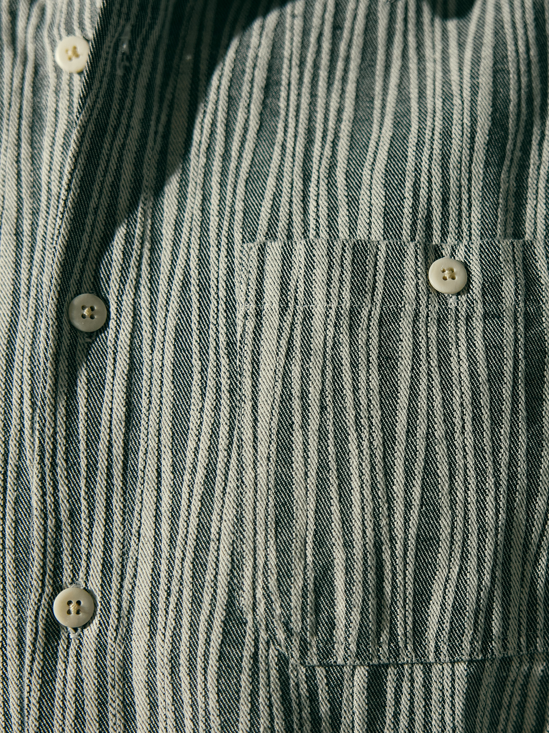 a close up of a person wearing a button down shirt